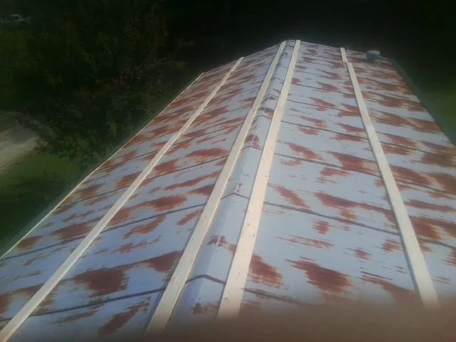 Rusted metal roof panels with new wood purlins before replacement — Storm Damage Roof Repair in Burnt Hills by Roofing Brothers