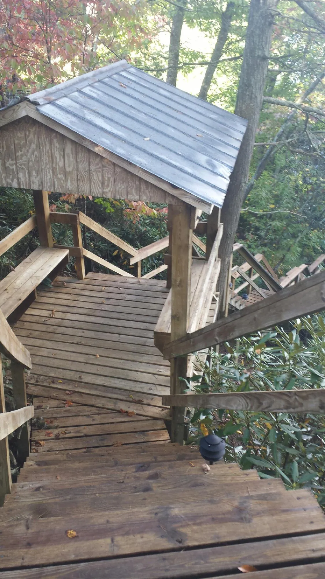 Metal roofed shelter over wooden steps on a wooded walkway — Skylight Repair & Installation work by our crew in Burnt Hills