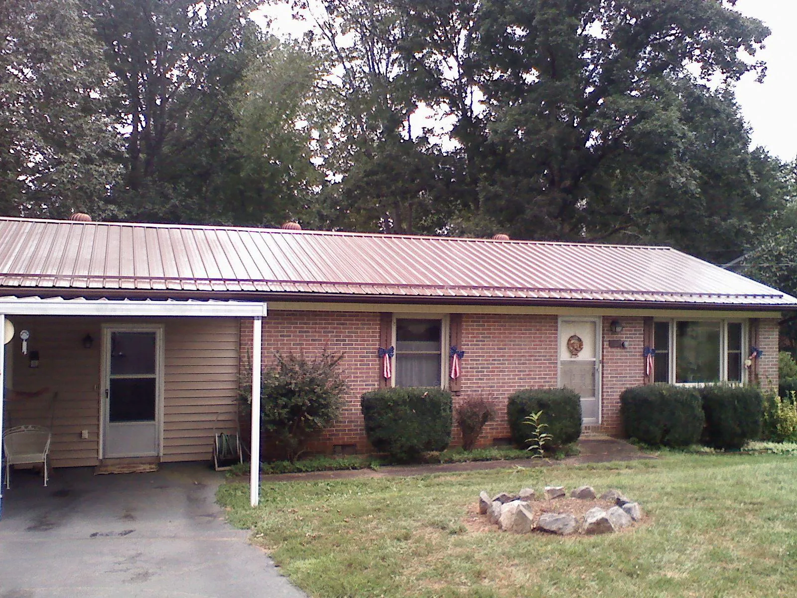 Bronze metal roof and carport on a brick ranch home — Roof Repair work by our crew in Burnt Hills
